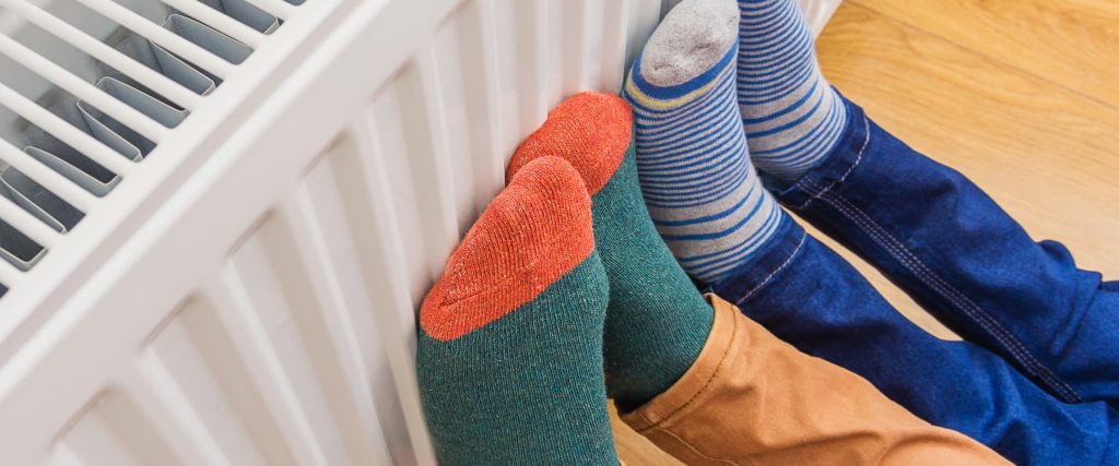 People With Feet Against Hot Radiator